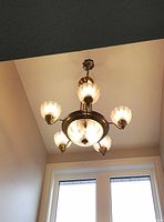 Chandelier installed and illuminated, showing design and shade style