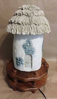 Full view of resin cottage lamp on wooden base