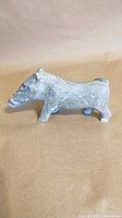 Side profile of grey stone boar figurine