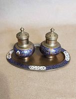 Salt and pepper shakers on brass tray showing full set