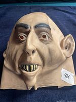 Front view of latex monster mask showing full facial details and neck bib