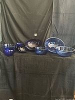Group of cobalt blue glass bowls displayed against black backdrop