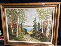 Framed landscape oil painting showing scene details and frame