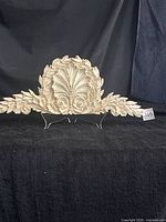 Front view of ornate resin wall pediment showing acanthus leaves and shell design