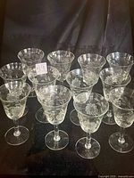 Group of 12 clear etched cornflower stemware glasses displayed upright
