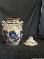 Front view showing vase decoration, handles, lid