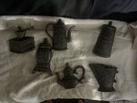 Six molded resin kitchenware plaques on towel