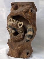 full view of chalkware raccoon figure within tree trunk