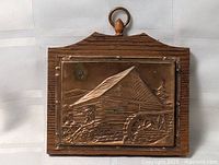 Front view of copper plaque on wood backing
