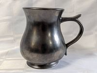 Front view of dark luster pottery tankard mug