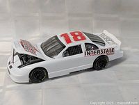 Left front three-quarter view showing hood open, decals and engine detail