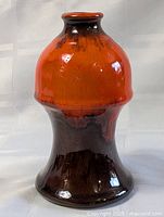 Front view of two-tone orange and brown pottery bud vase