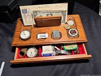Wooden jewellery box with various items placed on and inside