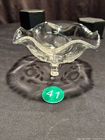 Full view of glass bowl showing three feet and ruffled rim