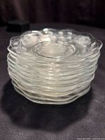 Stack of ten clear glass scalloped plates