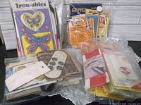 Grouped view of bagged packages: Iron-ables applique, snap fasteners, buttons, hem tape