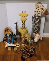 Group shot of all giraffe items including plush toys, metal and wood decor pieces