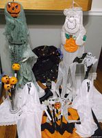 Entire lot overview showing hanging figures, rug, ghosts, vase with picks and other items