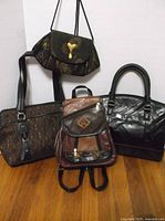 Group shot of all four handbags standing on floor