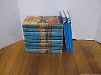 Stack of ten Hardy Boys hardcovers showing uniform blue spines, three with bright blue cloth bindings