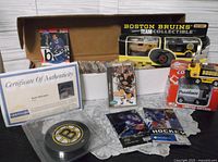 Full lot with signed puck, COA, boxed cards, die-cast vehicles, sealed packs displayed