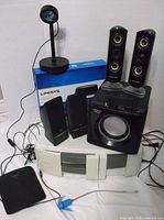 All items group view: Sharper Image 2.1 speakers, Linksys N600 box, Linksys E1200 router, clip-on light, PC speakers