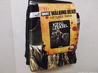 Front of packaged fleece throw showing AMC branding and King Ezekiel image