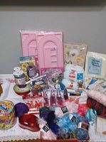 Lot overview with yarn, bead boards, ribbons, beads, cross-stitch fabric, pattern booklets