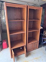 Front view of both matching lighted bookcases showing shelves, cabinet doors and light fixtures