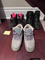 Three pairs of Air Jordan sneakers displayed on floor