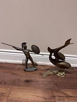 Front view of both brass statues standing upright on floor