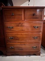 Front view of wood dresser showing four drawers and hardware