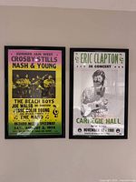 Two framed concert posters on wall