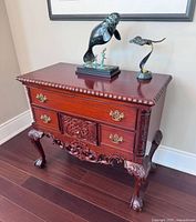 Front view of carved mahogany hall table showing drawers, carvings, legs and top