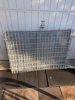 Both folded wire dog crates leaning against garage door