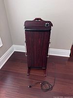 Front view of Salton pants press showing veneer finish, side handles, control knob and power cord