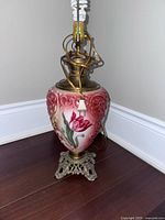 Full view of floral glass lamp body with metal base