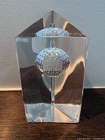 Front view showing suspended ball motif inside prism