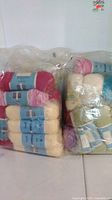 Both sealed bags of yarn showing quantity and colours