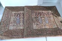 Two identical tapestry pillow covers laid flat showing front designs