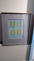 Front view of framed print showing masks and frame