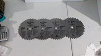 Four identical Vermont American 7-1/4" saw blades laid out side by side