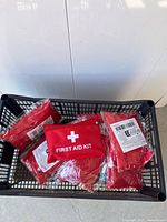 Basket containing multiple sealed red first aid kits