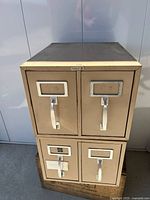 Front view showing both beige metal two-drawer cabinets stacked