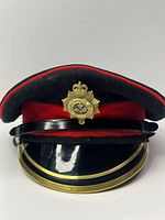 Front view of Canadian Guards cap with badge, visor and chin strap visible