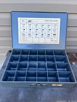 Closed case opened showing 24 compartments and chart on lid