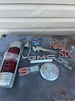 Group shot showing all nine vehicle emblems and parts laid out