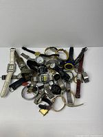 Pile of assorted wristwatches on white background