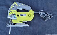 Left side view showing Ryobi branding, power cord and base plate