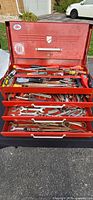 Overall view of open red toolbox with drawers and contents